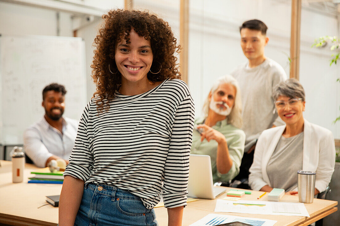 Project manager standing while looking at the camera during meeting