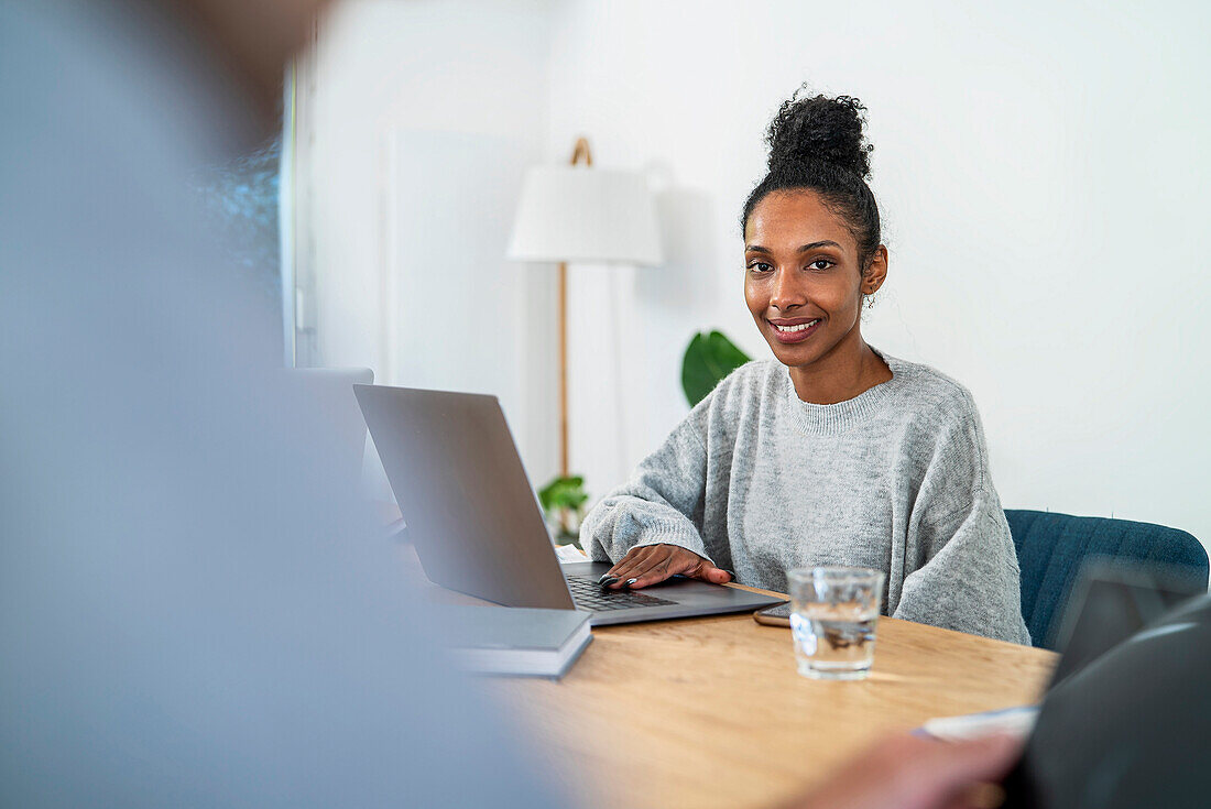 Financial assistant sitting at desk using laptop