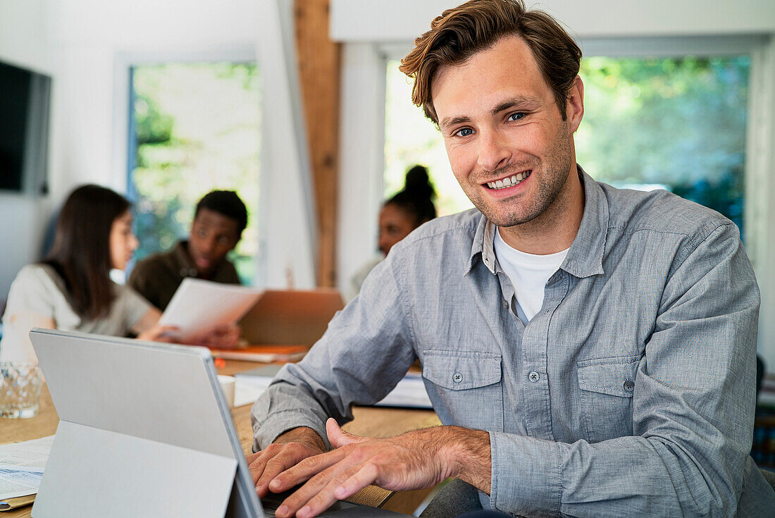 Male business administrator looking at the camera while working at desk