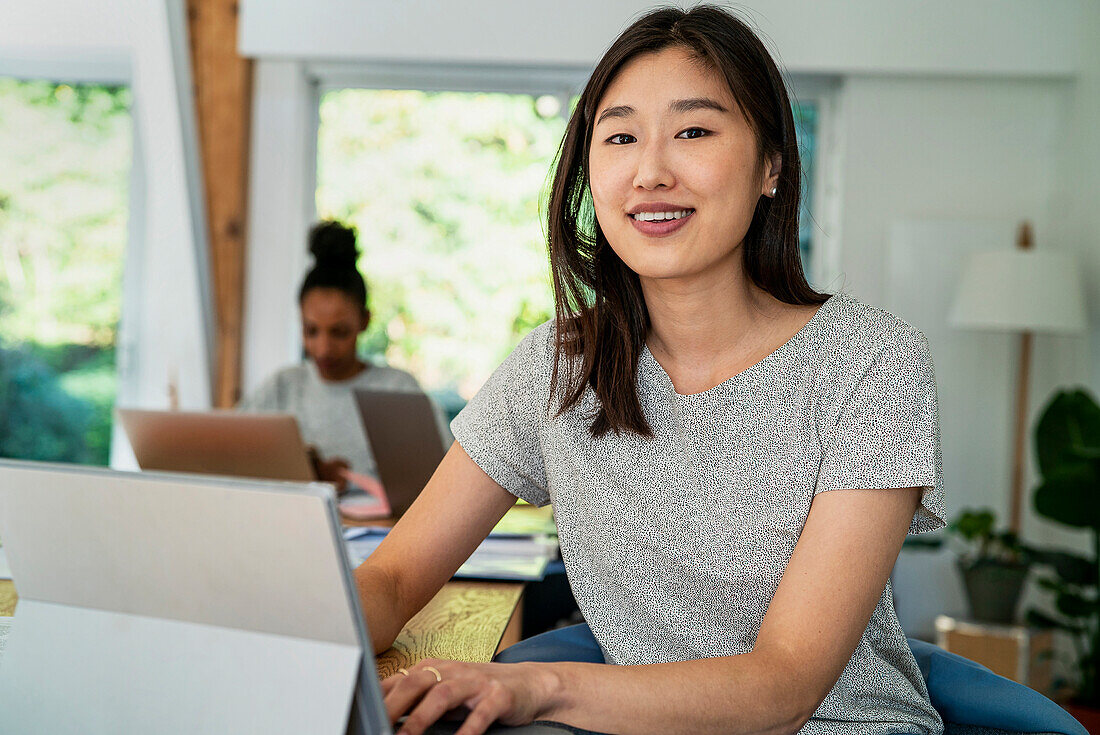 Female community manager using digital tablet while sitting at desk