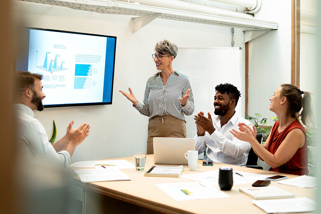 Coworkers celebrating project presentation made by businesswomen