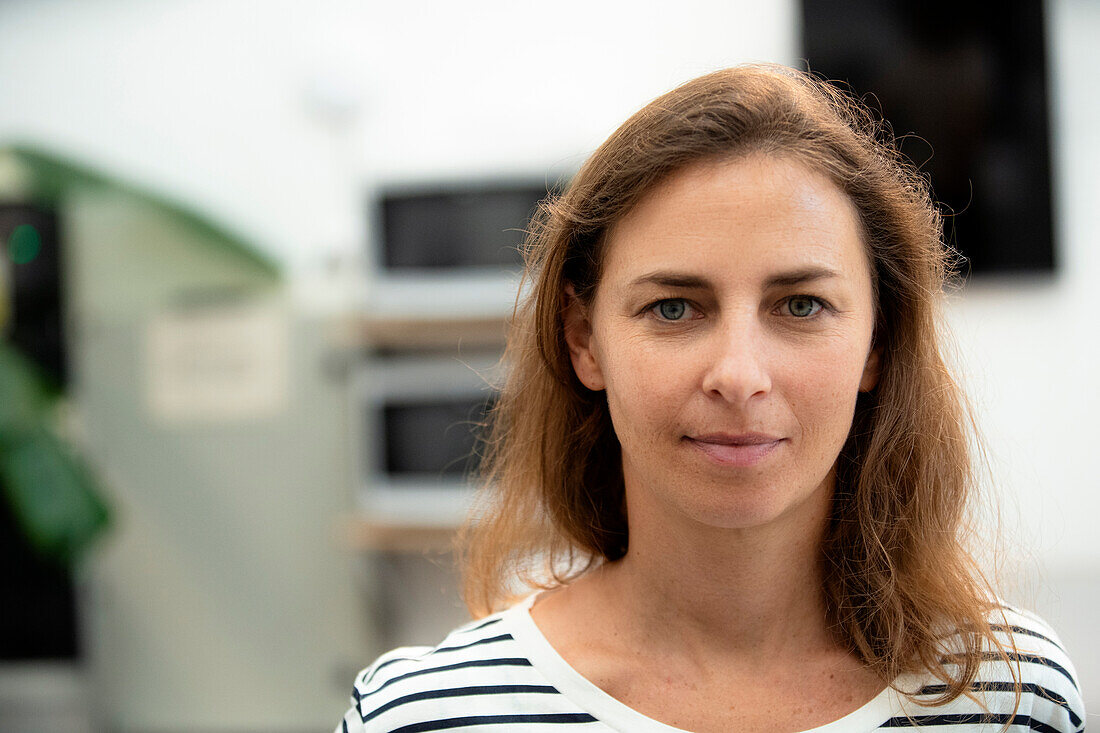 Adult woman looking at the camera while standing indoors