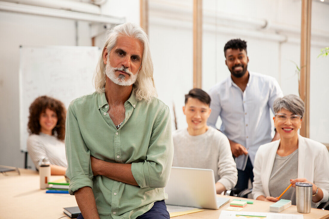 Männlicher Industriedesigner, der in die Kamera schaut, während er in einem Büro steht