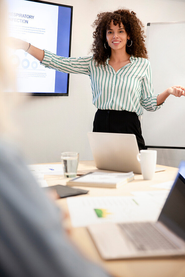 Businesswoman discussing project with colleagues at meeting room