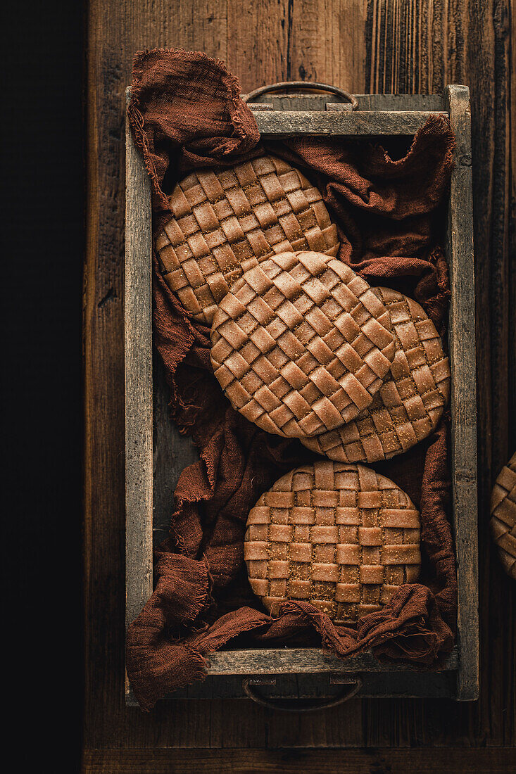 Mini apple pies with lattice pastry topping on a wooden table