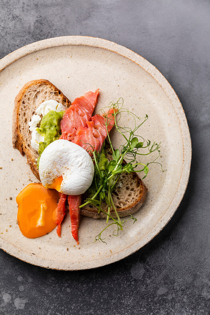 Sandwich mit rotem Fisch, Guacamole und pochiertem Ei