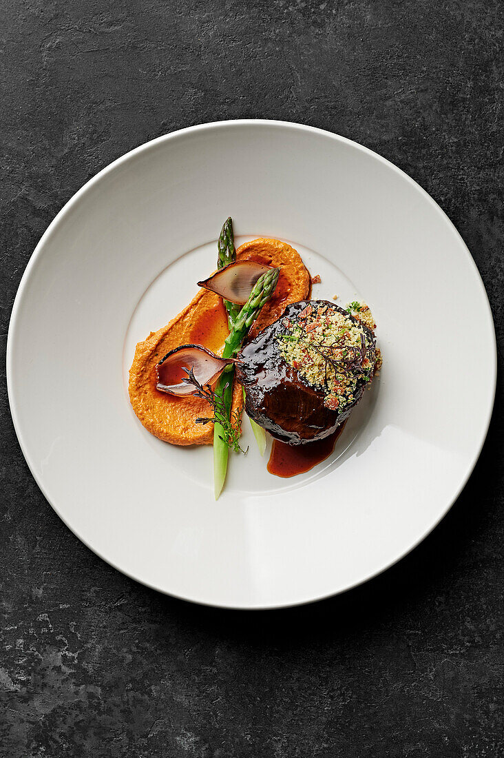 Slow-cooked beef cheek, charred shallots, asparagus spears, romesco, pancetta herb breadcrumbs