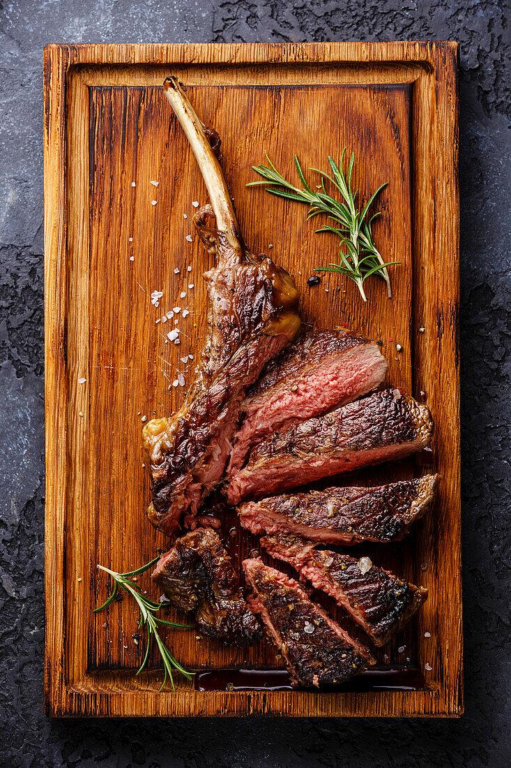 Sliced grilled Medium rare barbecue Steak on bone Veal rib on dark background