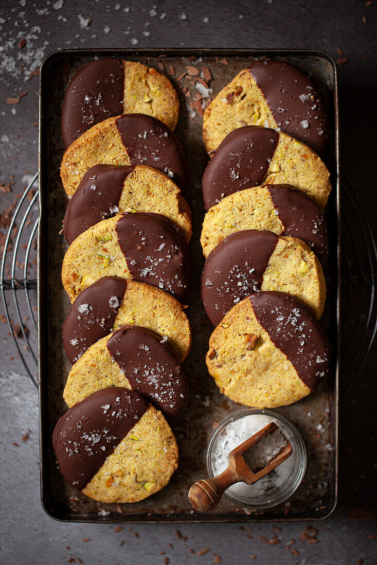 A tray of pistachio shortbread dipped in dark chocolate and sprinkled with sea salt