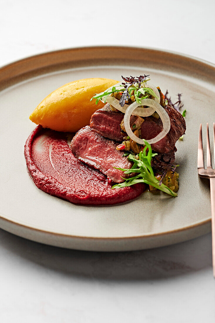 Lamb saddle fillet, sweet potato puree, blood plum romesco, pickled white onions, green olive and coriander salsa