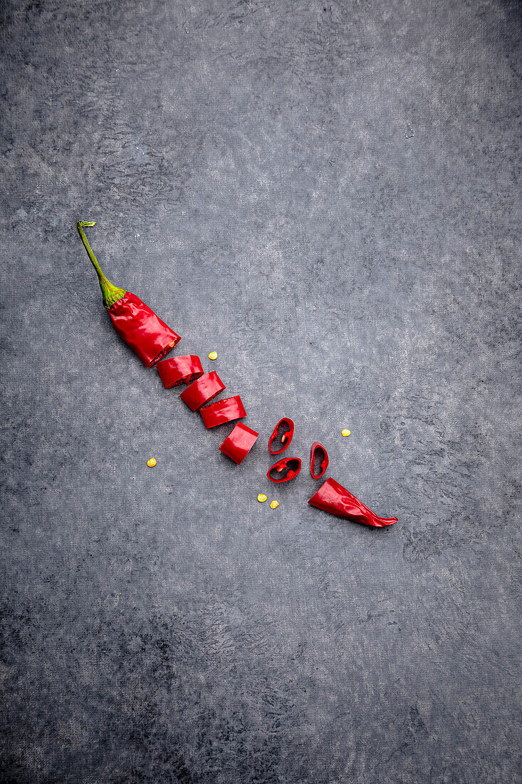 Sliced chilli pepper on a grey background