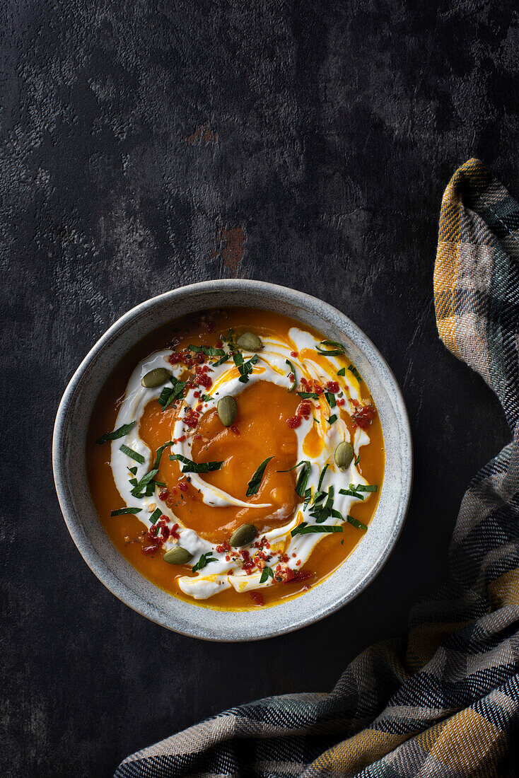 Pumpkin cream soup with yogurt and seeds. Top view.