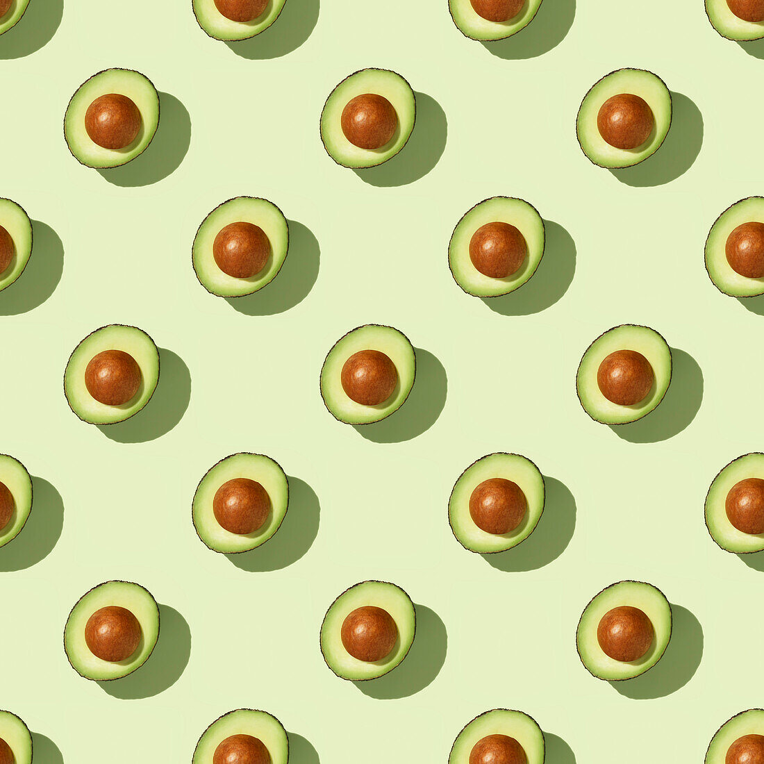 Avocado on green background pattern top view flat lay. Summer color. Minimal concept