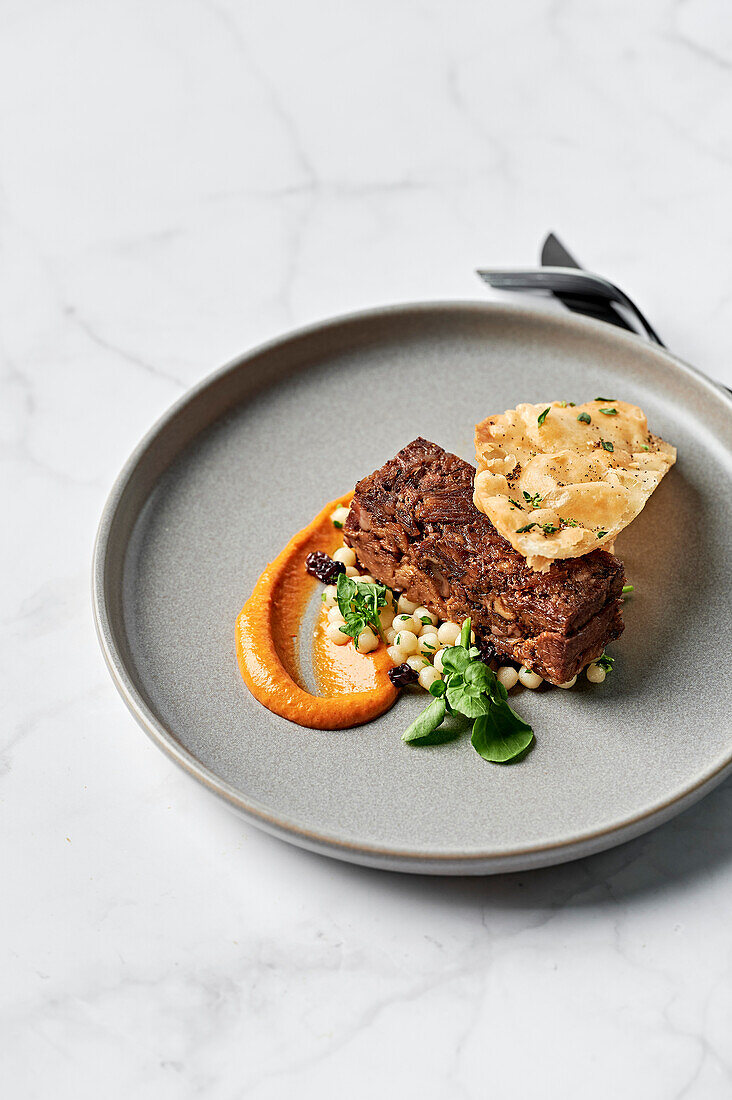 Langsam gekochte Sumach-Lammschulter, Harissa-Sauce, Koriander-Couscous-Salat, knuspriges Luchi-Fladenbrot