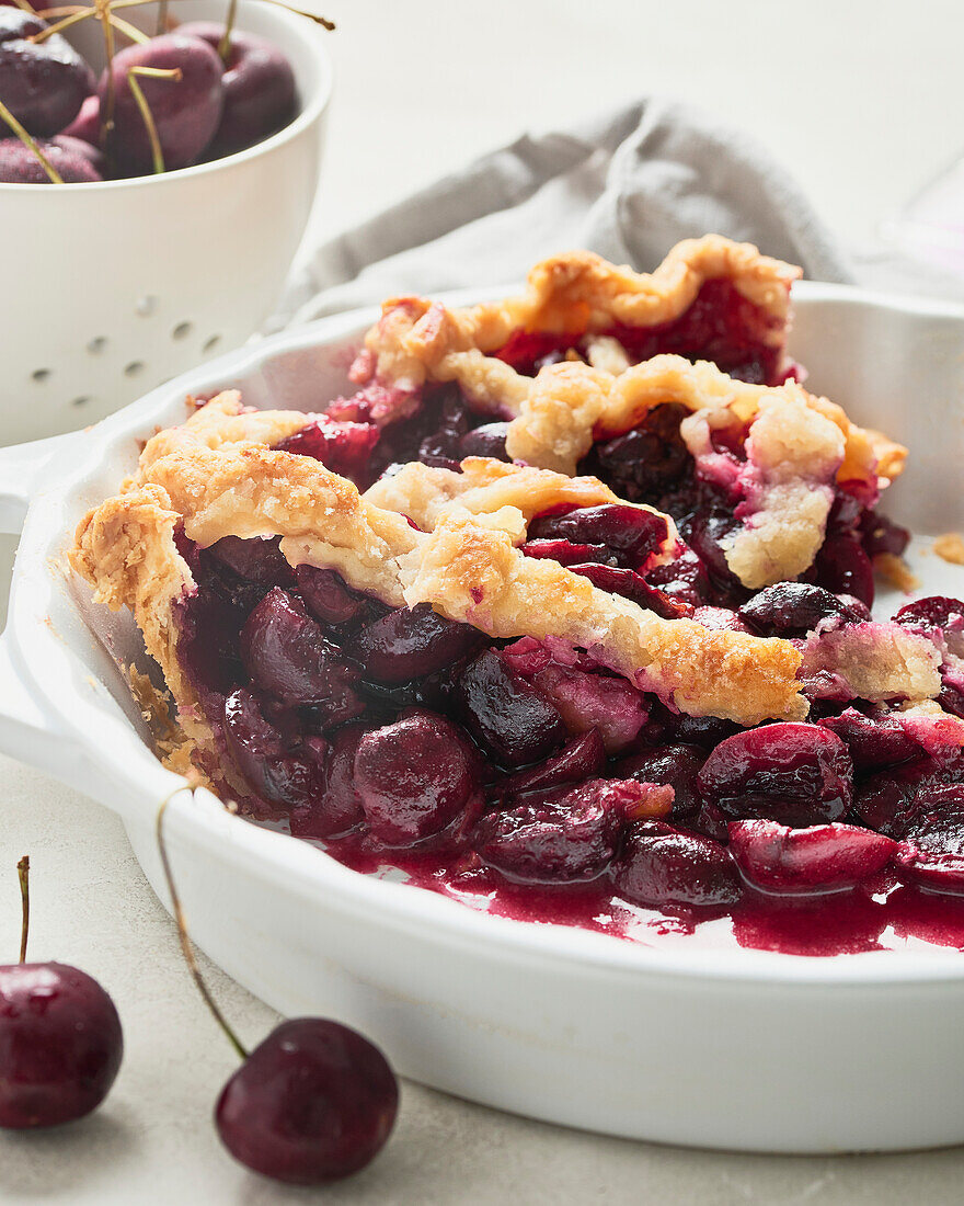 Vegan cherry cake in a white cake tin