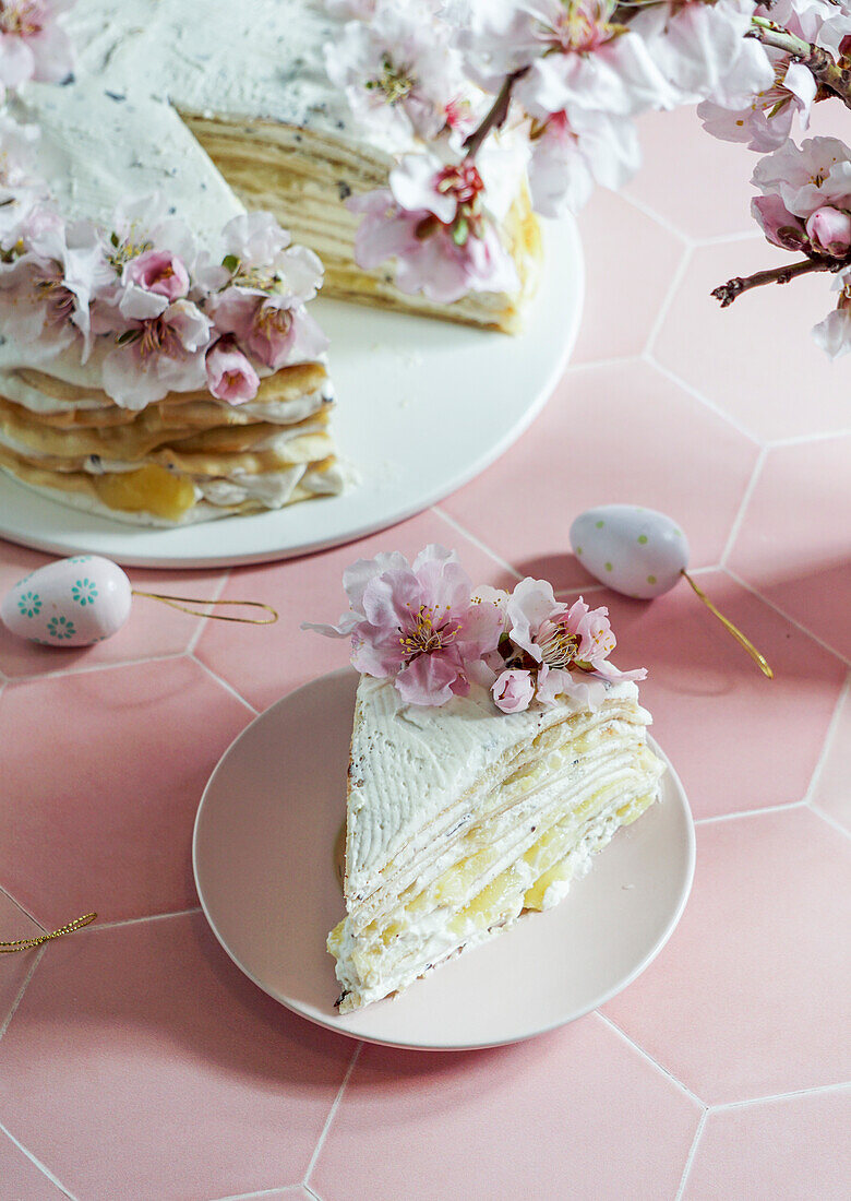 Krepptorte oder Blini-Torte für Osterfest, rosa Hintergrund, Mandelblüten, rosa Hintergrund, Frauenhände