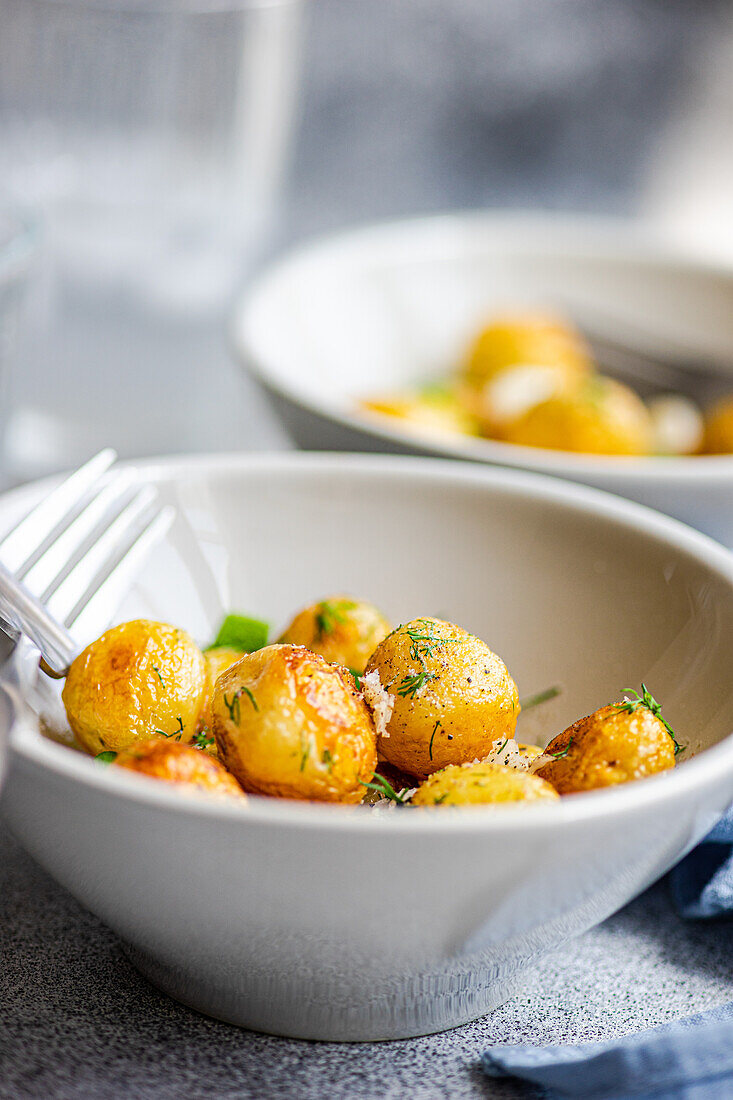 Roasted spring potato vegetables with herbs, served in a bowl for lunch