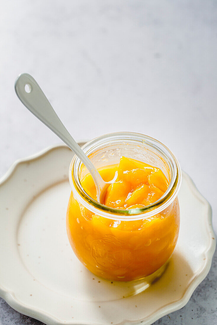 Mango compote dessert in a glass with spoon