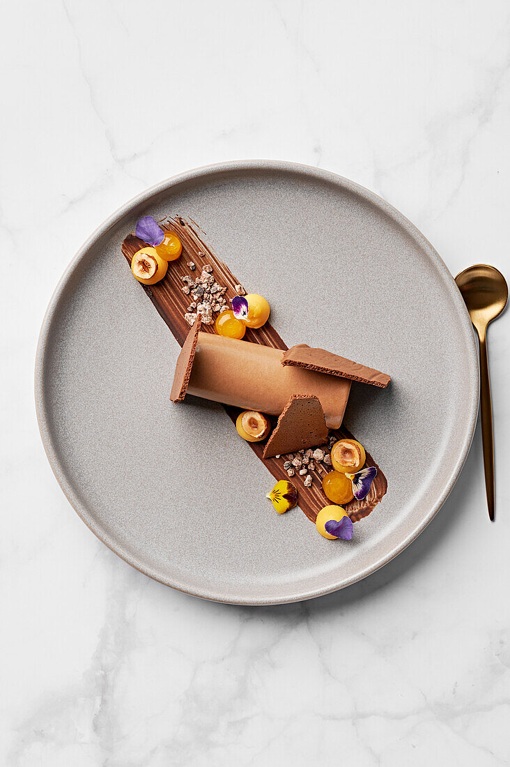 Chocolate mousse, passion fruit quark, candied hazelnuts, cocoa nib praline, passion fruit gel, dried chocolate