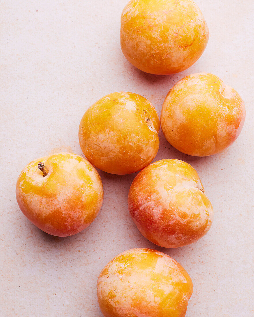Yellow plums on a light pink background