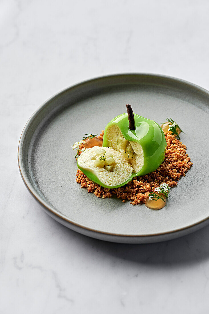 Green apple filled with vanilla bean & white chocolate mousse, apple & dill compote, and served with salted oat crumble and apple gel