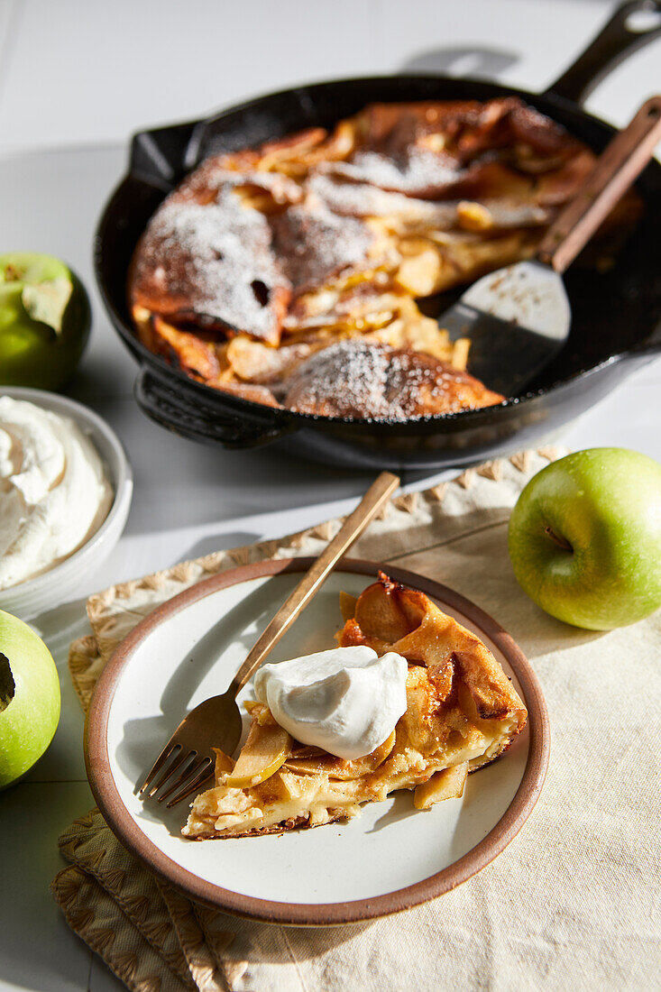 German apple pancake with pan and plates