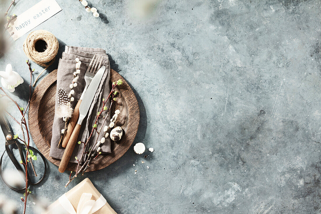 Easter table with spring flowers and cutlery on a dark blue background, top view, laid flat. Happy Easter concept for cafés and restaurants. Copy space