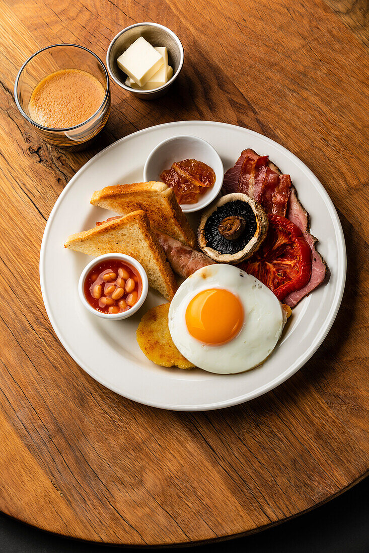 Komplettes englisches Frühstück mit Spiegeleiern, Würstchen, Speck, Bohnen und Toast