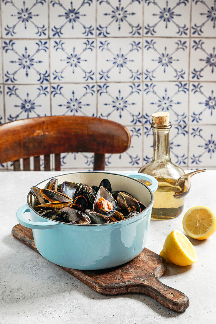 Mussels in white wine and lemon juice in a blue cast-iron casserole dish
