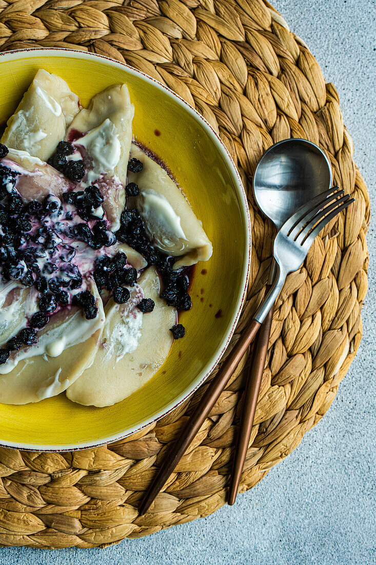 Delicious traditional Ukrainian dumplings with blueberries and sour cream