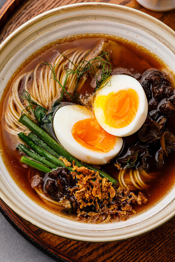 Ramen, asiatische Nudeln in Brühe mit Rinderzunge, Pilzen und Eiern in einer Schüssel