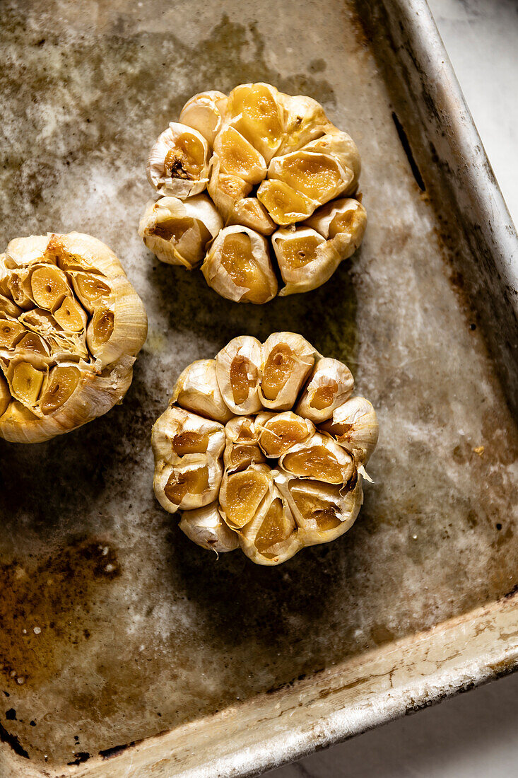 Home-baked garlic cloves on a baking tray