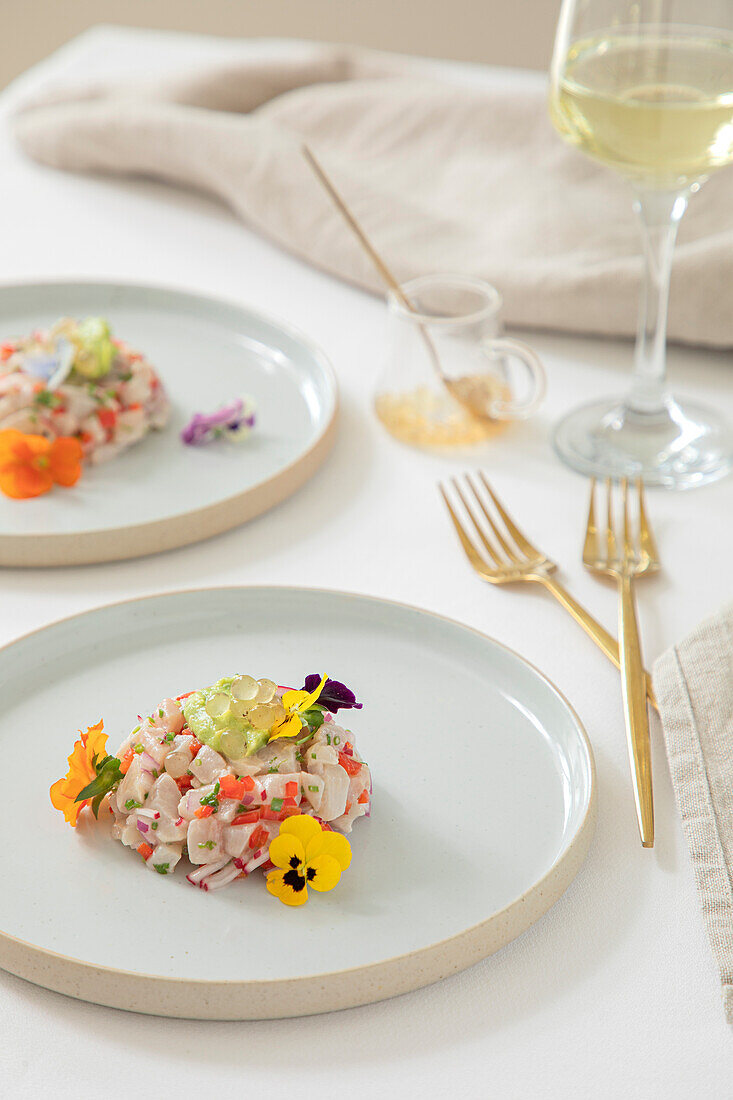 Kingfish Tartare served with edible flowers in a restaurant