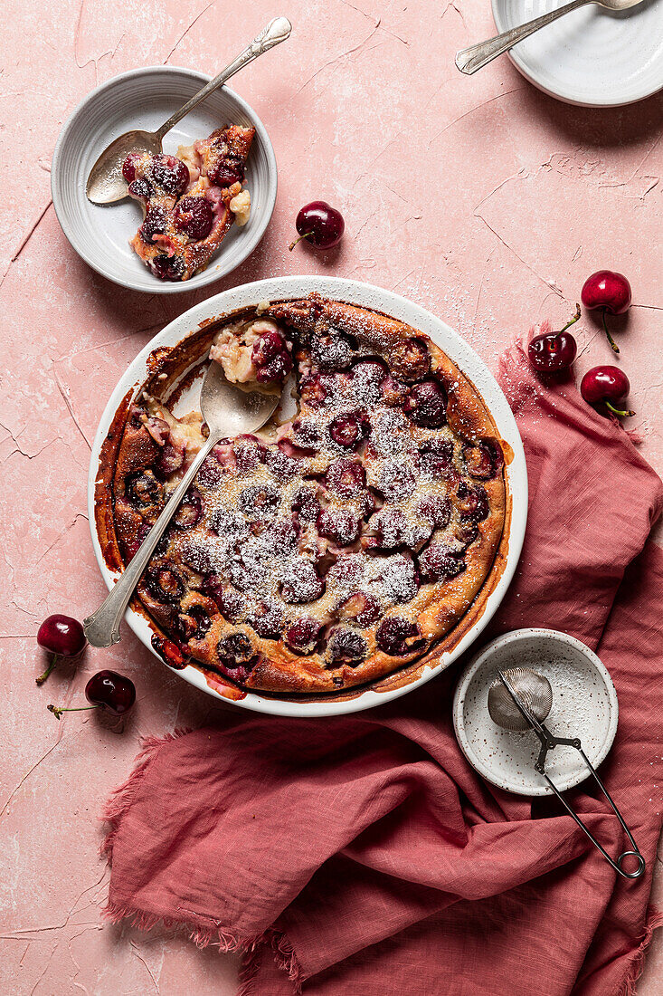 Kirschen-Clafoutis auf rosa Hintergrund