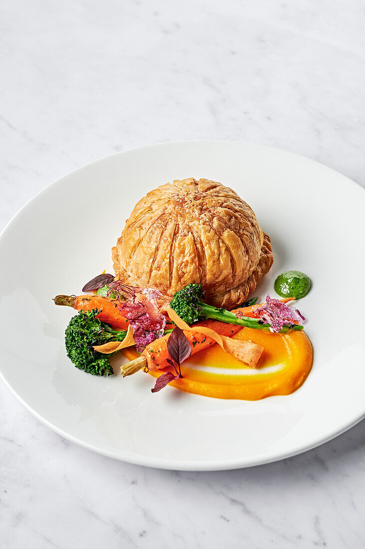 Blätterteigpithivier mit Karottenpüree, verkohlten Broccolini, Babymöhren und Salsa verde