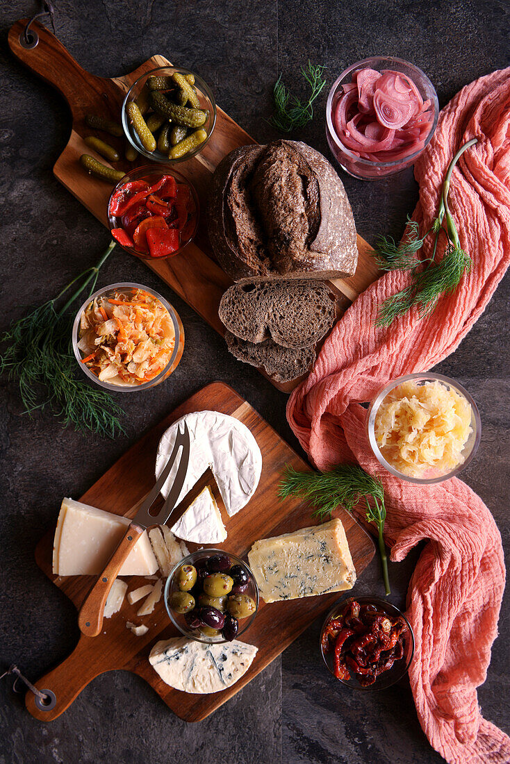 Healthy probiotic cheese platter with kimchi, dark coloured sourdough bread and fermented vegetables