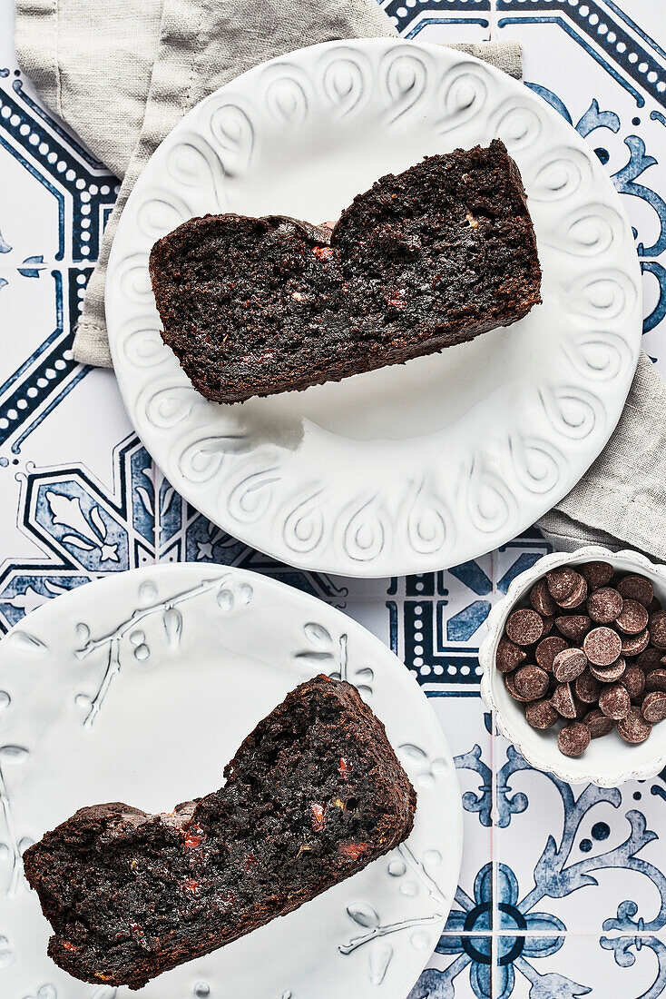 Two slices of chocolate banana bread on white plates