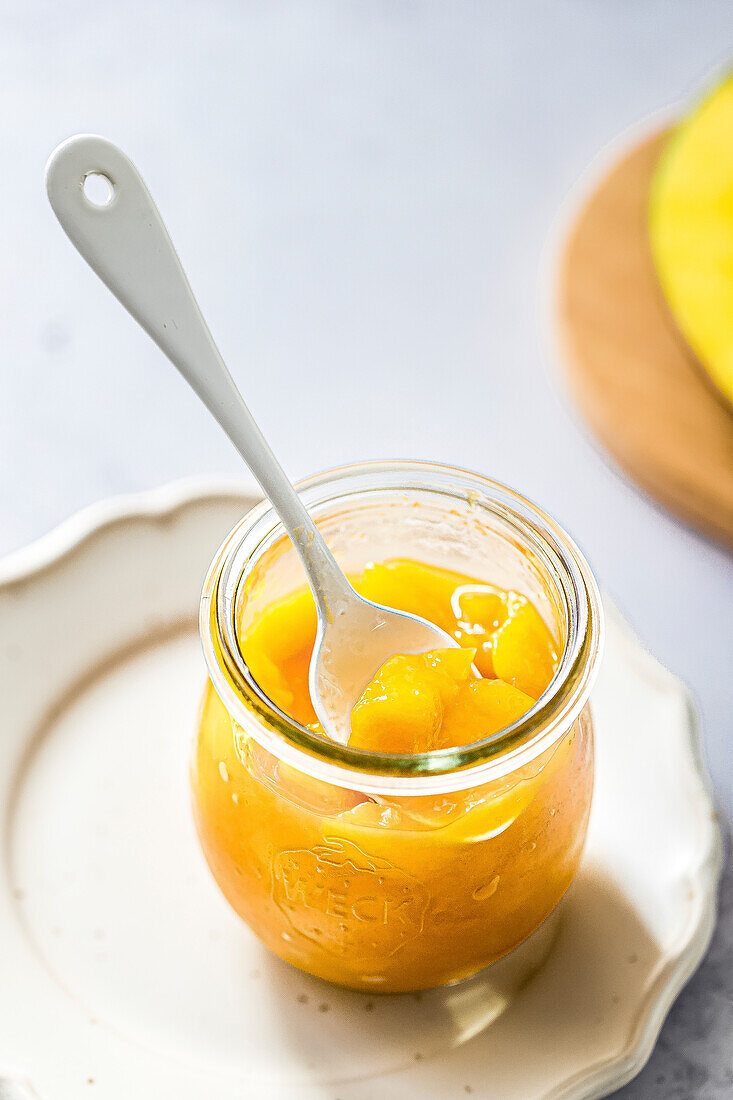 Mango compote dessert in a glass with spoon