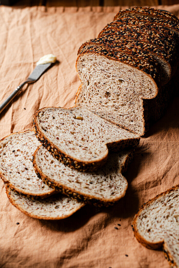 A loaf of seeded bread cut into slices