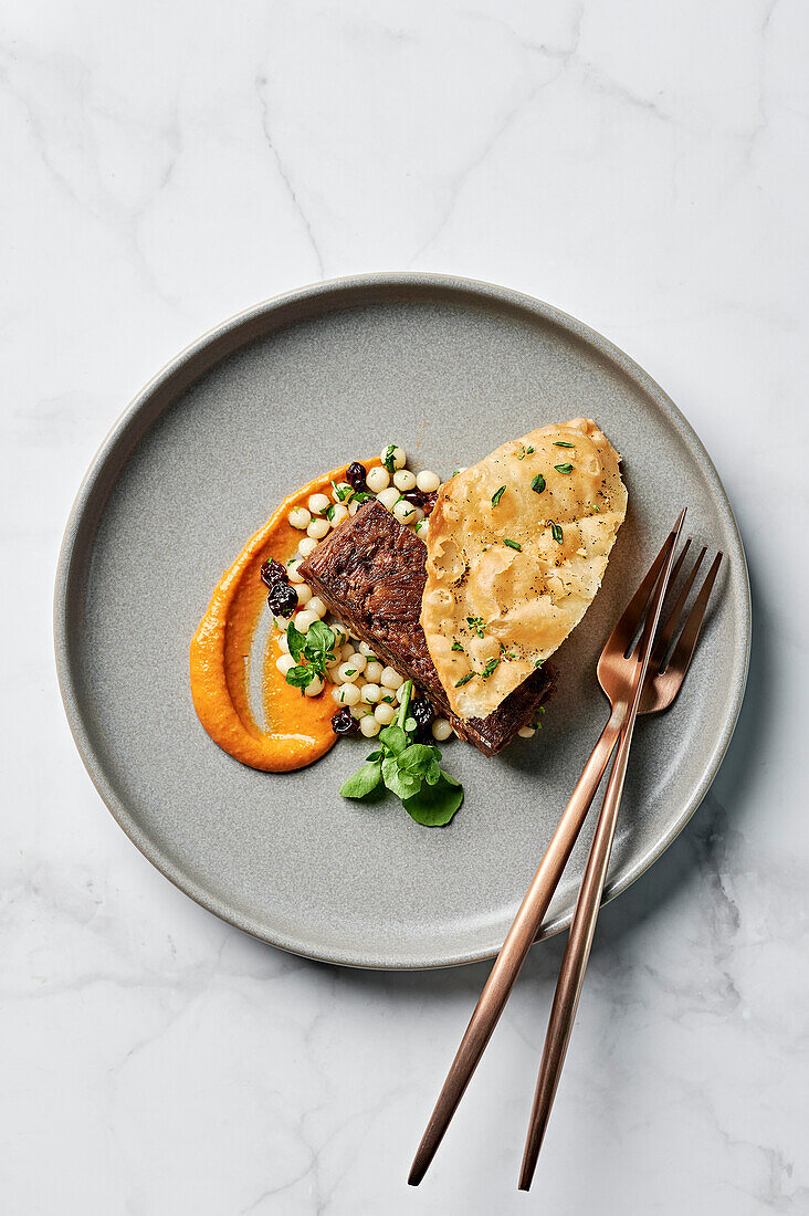 Slow-cooked sumac lamb shoulder, harissa sauce, coriander couscous salad, crispy luchi flatbread