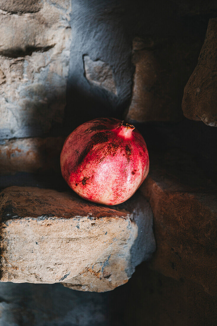 Single pomegranate on a stone surface