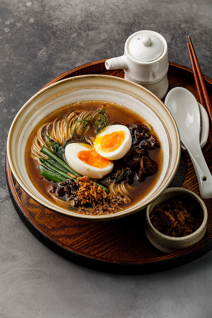 Ramen, Asian noodles in broth with beef tongue, mushrooms and eggs in a bowl