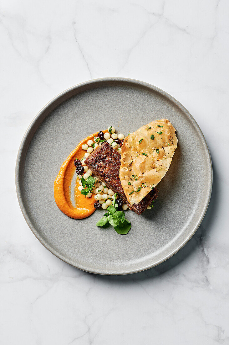 Slow-cooked sumac lamb shoulder, harissa sauce, coriander couscous salad, crispy luchi flatbread