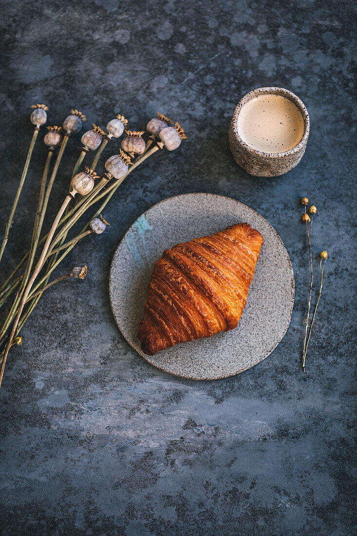 Croissant auf einem Keramikteller serviert