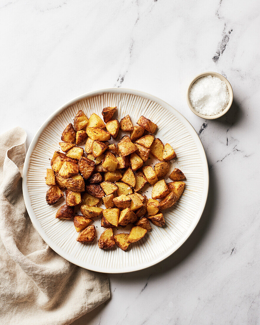 Plate of fried potatoes with beige napkin