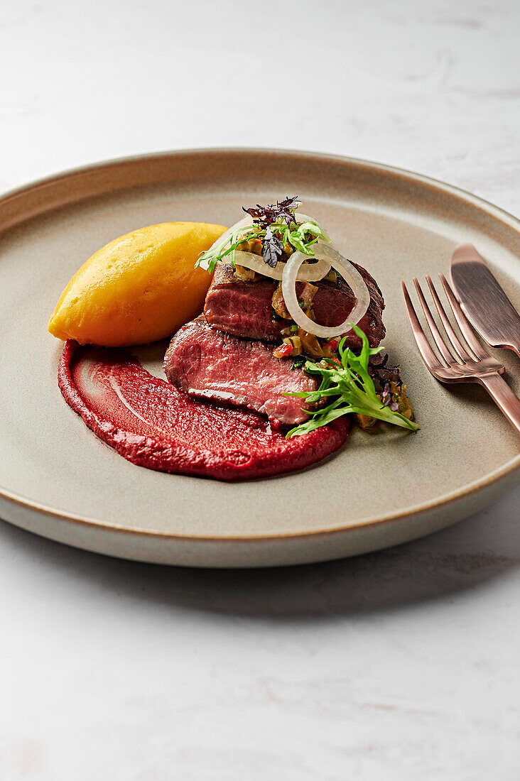 Lamb saddle fillet, sweet potato puree, blood plum romesco, pickled white onions, green olive and coriander salsa