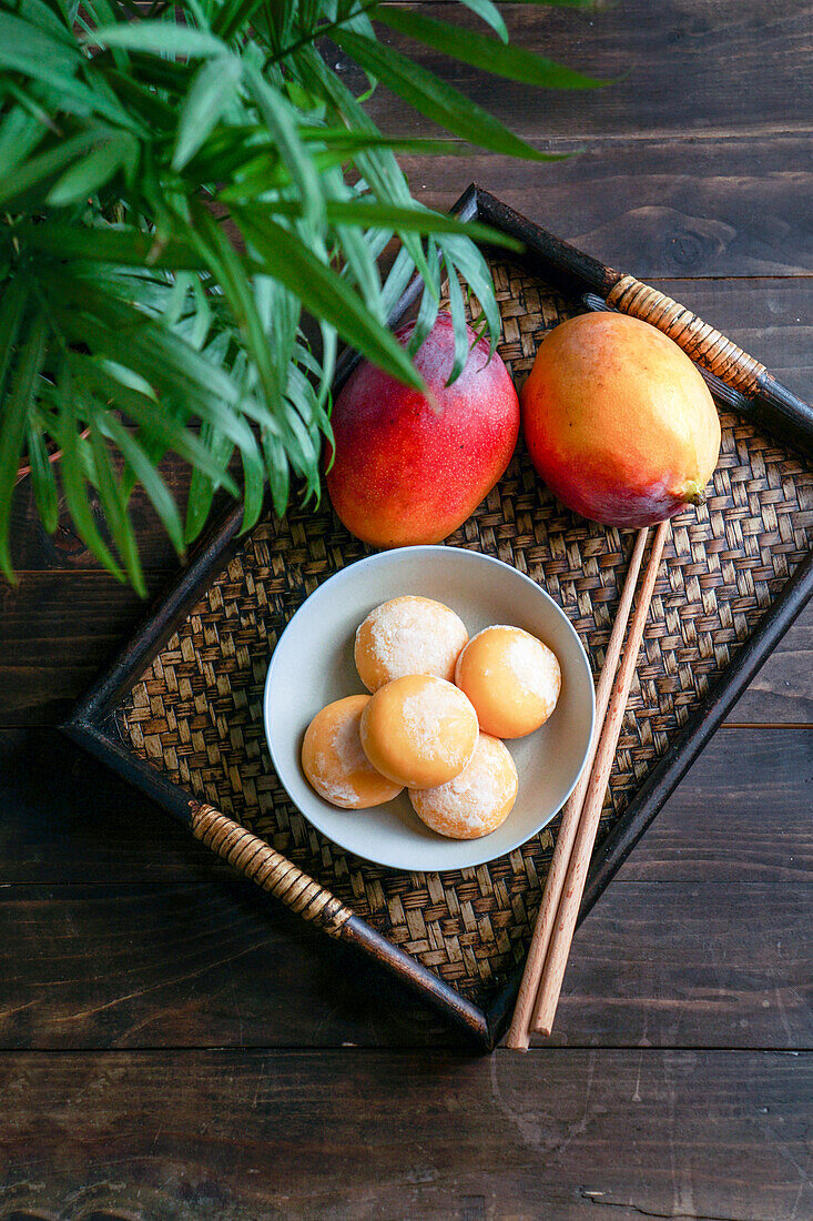 Japanische Mango-Mochi-Törtchen mit Eiscreme auf einem klassischen asiatischen Holztablett