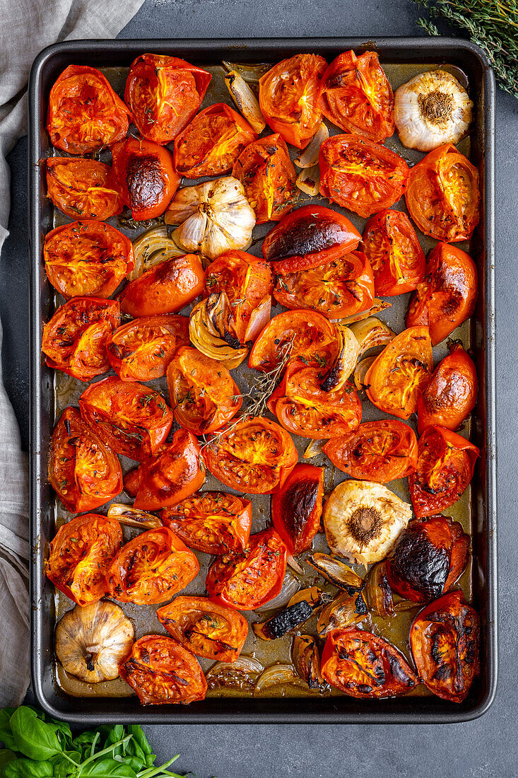 Tomatoes, onions and garlic roasted on a baking tray
