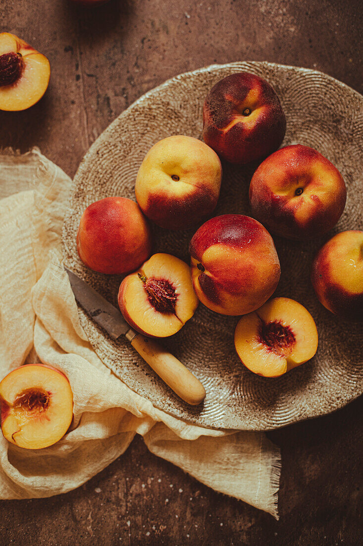 Ripe peaches are prepared on a kitchen table