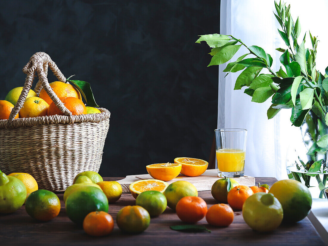 Erntekorb mit Orangen, Zitronen und Tangarinen auf einem rustikalen Tisch